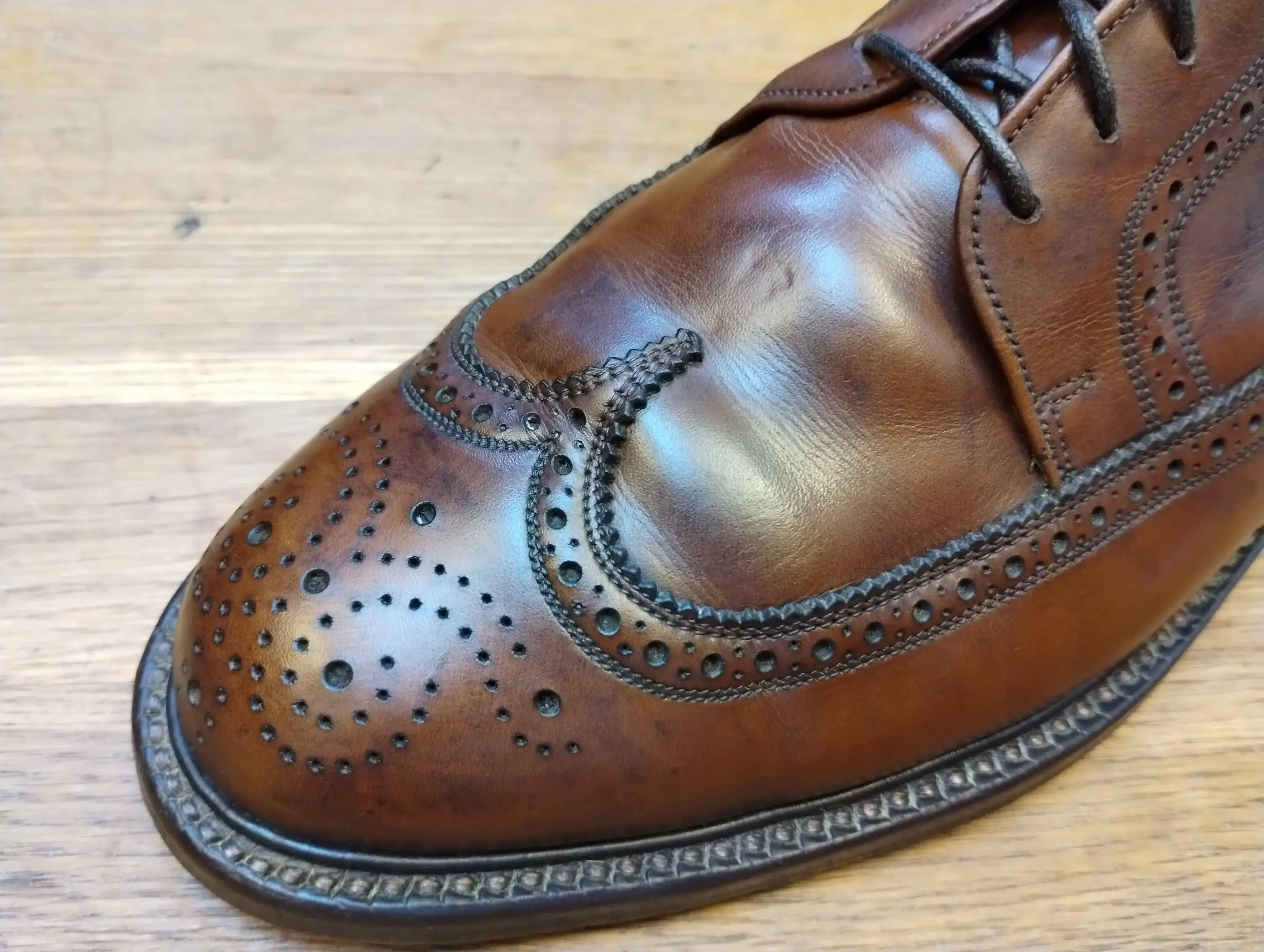 A pair of scuffed leather shoes before restoration